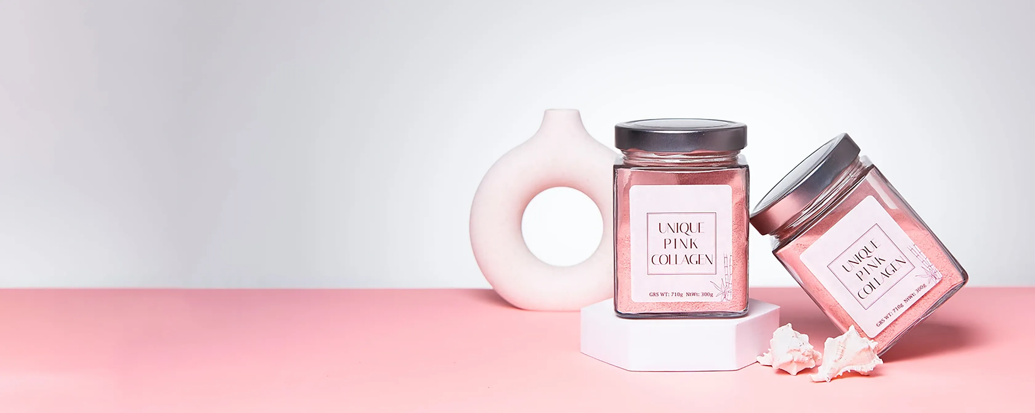 Две банки UNIQUE Pink Collagen на розовом подиуме
